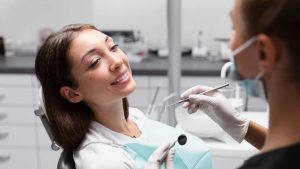 A patient smiling in the dentist's chair during a consultation with a dental professional.