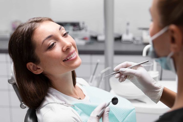 A patient smiling in the dentist's chair during a consultation with a dental professional.