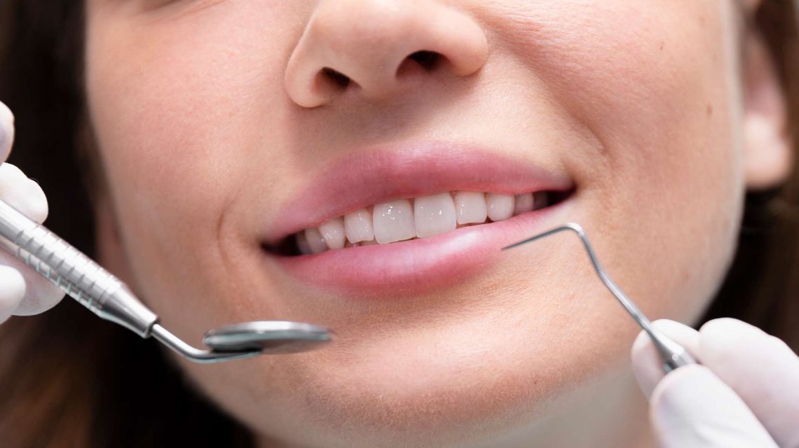 Close-up of a patient’s smile during a dental check-up with dental tools in view