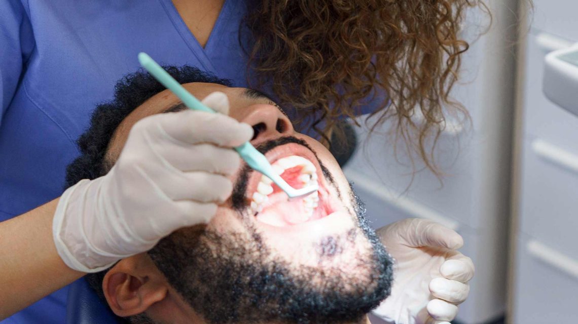 Patient receiving dental treatment for veneers on crooked teeth at the dentist’s office