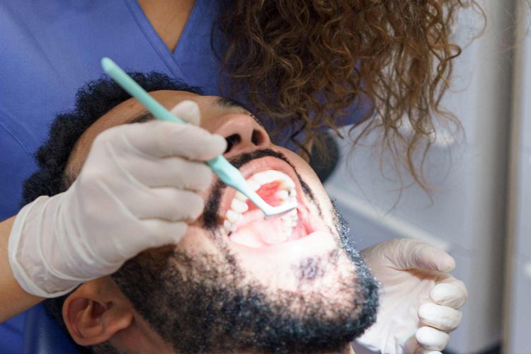 Patient receiving dental treatment for veneers on crooked teeth at the dentist’s office